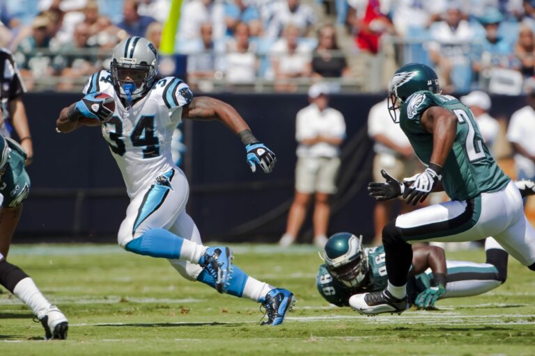 The running back player runs against the other team